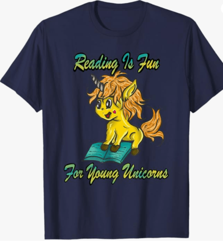 A navy blue t-shirt featuring a cartoon unicorn with yellow fur and orange mane sitting on an open book, accompanied by the text 'Reading Is Fun For Young Unicorns' in colorful lettering.
