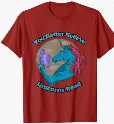 A red t-shirt featuring a cartoon unicorn with a blue body and pink mane, holding a book, accompanied by the text 'You Better Believe Unicorns Read'.